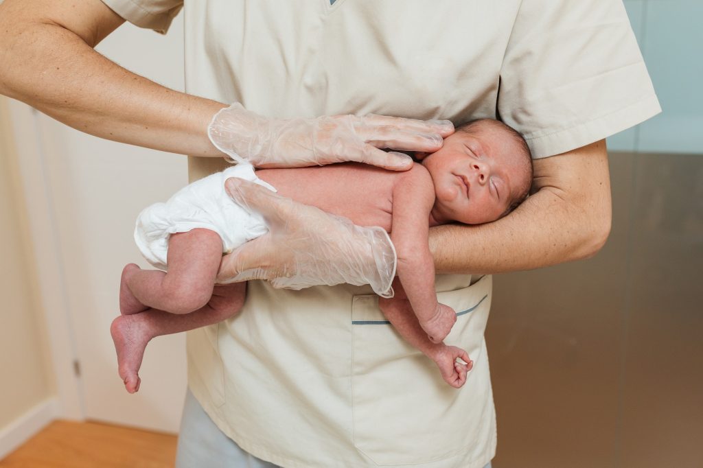 Close up view of a medical doctor examining a newborn baby