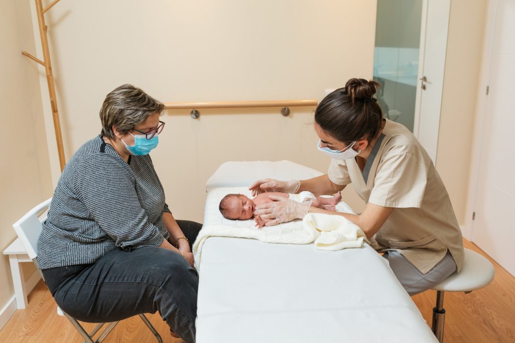 Female pediatric physiotherapist working with the newborn in a medical center
